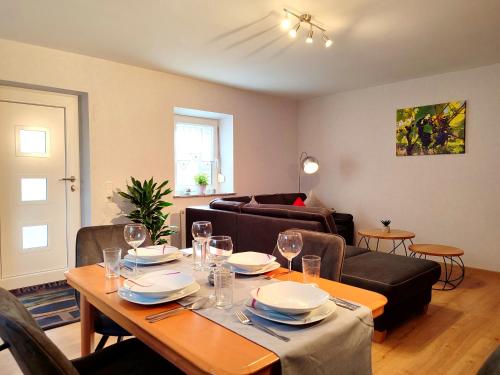 a living room with a table and a couch at Ferienwohnung Neubert im Taubertal in Elpersheim