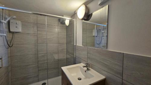 un baño con lavabo y espejo en Clydesdale Apartments, en Torquay