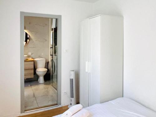 - une chambre avec un lit et une salle de bains avec un miroir dans l'établissement Loft Strasbourg proche Petite France, à Strasbourg