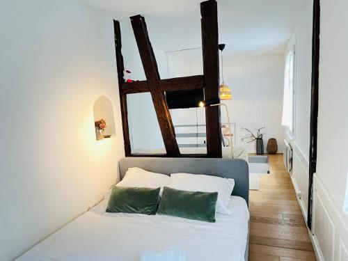 une chambre avec un lit avec des draps blancs et des oreillers verts dans l'établissement Loft Strasbourg proche Petite France, à Strasbourg