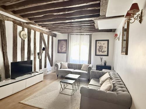 a living room with a couch and a tv at 80 m2-Heart of Le Marais -Sleeps 6 in Paris