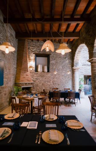 a dining room with tables and chairs and a stone wall at Hotel Antiguo Vapor Categoría Especial in Guanajuato