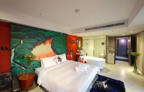 a bedroom with a large bed and a bath tub at Hotelday Tamsui in Tamsui