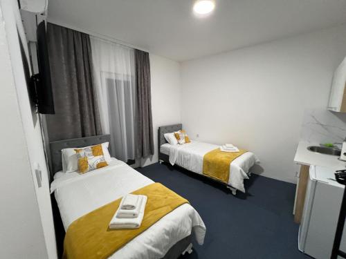a hotel room with two beds and a sink at Urban Heart Residence in Sarajevo