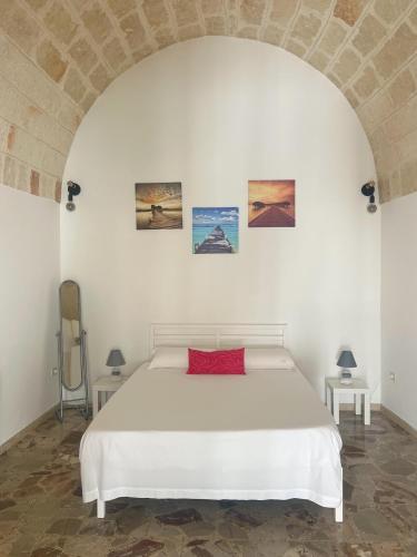 una camera da letto bianca con un letto bianco e due tavoli di Juli's house a Polignano a Mare