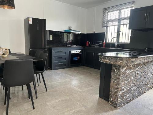 a kitchen with black cabinets and a stone counter at Blaclava Retreat in Balaclava