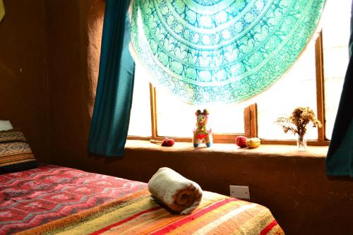 a bedroom with a window with a bed and a blanket at Sacred Valley Mystic Tribe - Community Life in Pisac