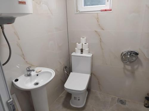 a white bathroom with a toilet and a sink at Apartments Maki 1 in Tivat