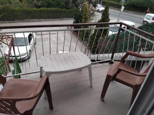 a balcony with two chairs and a table and a car at Apartments Maki 1 in Tivat