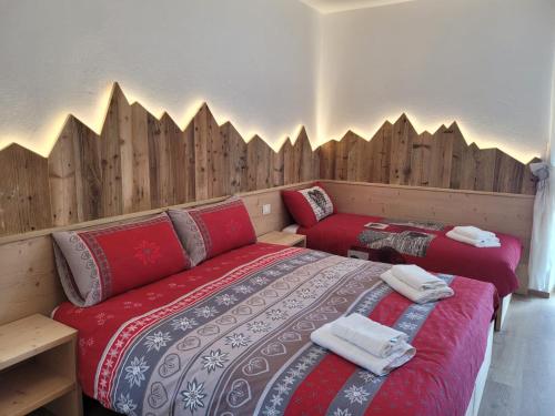 a bedroom with two beds and wooden walls at Posta Apartments in Colle Santa Lucia