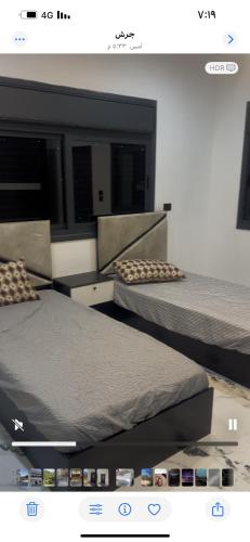 two beds in a room with avertisement at فيلا مفروشه ومزرعه للايجار in Jerash