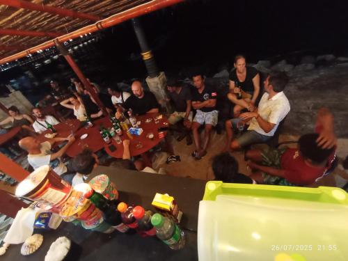 a group of people sitting around a table in a room at Three Ken Homestay & Cafe in Manado
