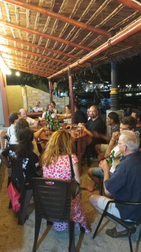 a group of people sitting at tables in a restaurant at Three Ken Homestay & Cafe in Manado