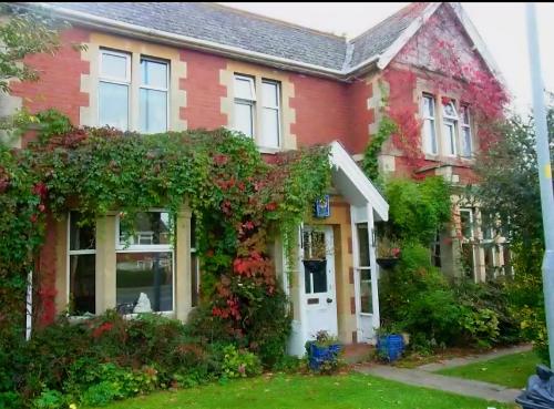 a red brick house with a white door at Redwood Lodge in Westbury