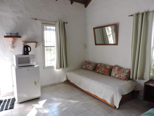 a small bedroom with a bed and a microwave at Complejo Azahares in Gualeguaychú