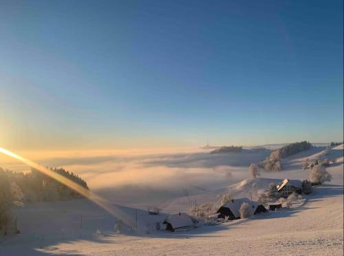 a view of a snow covered hill with a blanket of clouds at Chalet in der Natur in Walkringen
