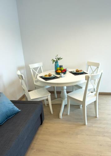 a white dining room table and chairs with food on it at 103 - Beachside Renovated 1BR apt w private garden in Cambrils