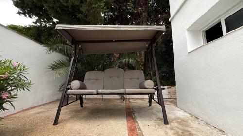 a couch sitting under a canopy in a backyard at 103 - Beachside Renovated 1BR apt w private garden in Cambrils
