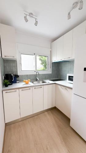 a white kitchen with white cabinets and a sink at 104 - Beachside Renovated 1BR apt 5 min from Beach in Cambrils
