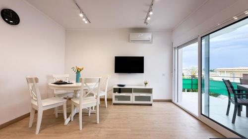 a dining room with a table and a tv at 109 - Beachside Renovated 1BR apt 5 min from Beach in Cambrils