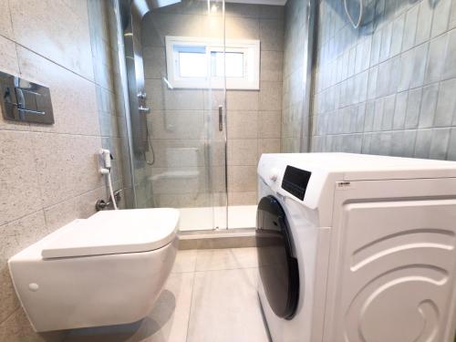 a bathroom with a toilet and a glass shower at 106 - Beachside Renovated 1BR apt 5 min from Beach in Cambrils