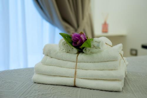 a pile of towels with a flower on top at Tabula Maris B&B in Trani