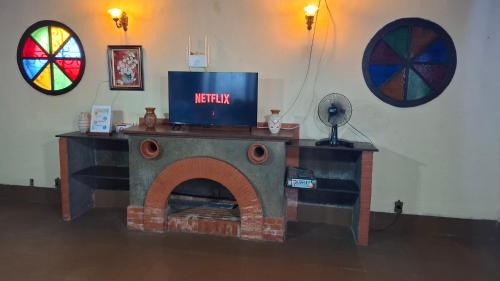 a living room with a fireplace with a tv on top at Moka Refúgium-Casa de praia aconchegante e espaçosa in Belém
