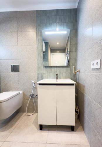 a bathroom with a sink and a toilet and a mirror at 107 - Beachside Renovated 1BR apt 5 min from Beach in Cambrils