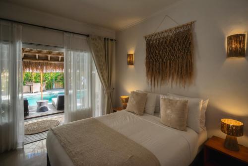 ギリ・アイルにあるSol Villas - Modern Tropical Staysのベッドとガラスの引き戸のある寝室