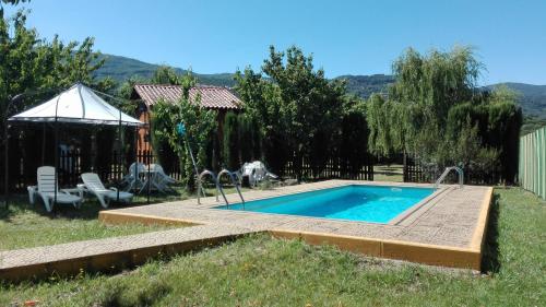 een zwembad in een tuin met een hek bij Apartamentos Rurales El Rincón del Jerte in Rebollar