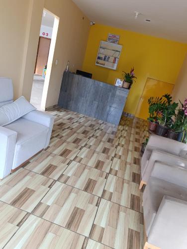 a living room with a wooden floor and yellow walls at Hotel Atalaia in Vitória da Conquista