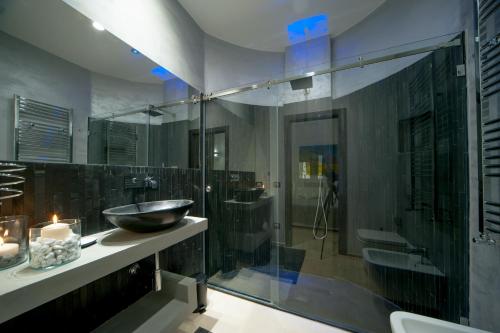 a bathroom with a sink and a glass shower at Tabula Maris B&B in Trani
