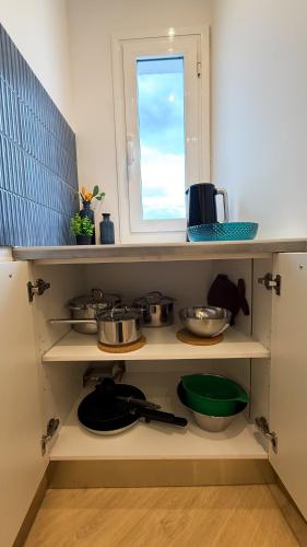 a kitchen with white shelves with pots and pans at 106 - Beachside Renovated 1BR apt 5 min from Beach in Cambrils