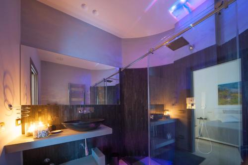 a bathroom with a sink and a glass shower at Tabula Maris B&B in Trani
