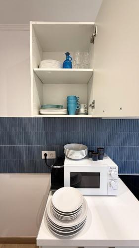 a kitchen with a microwave and plates on a counter at 107 - Beachside Renovated 1BR apt 5 min from Beach in Cambrils