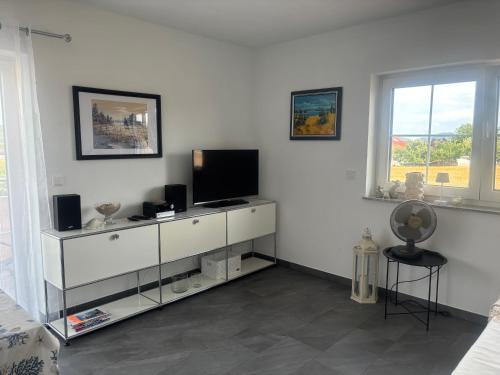 a living room with a tv on a white dresser at Auszeit in Volkertshausen