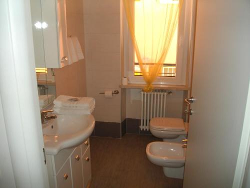 bagno con due servizi igienici, lavandino e finestra di Giulietta e Romeo a Peschiera del Garda