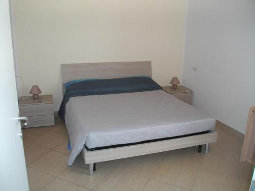 un letto in una camera da letto con due comodini e due lampade di Giulietta e Romeo a Peschiera del Garda