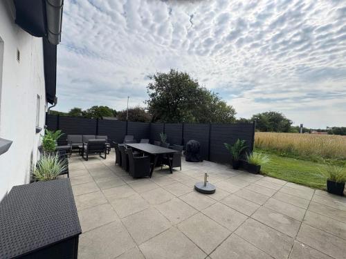 a patio with a table and chairs and a fence at 4 star holiday home in Henne in Henne
