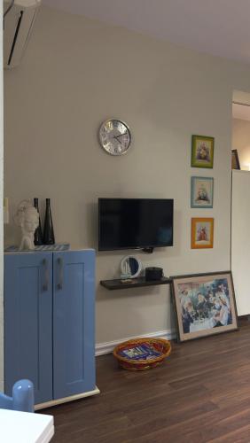 a living room with a blue cabinet and a clock on the wall at Ho&En - Coastal Serenity Entire Rental Unit in Durrës, Albania in Durrës