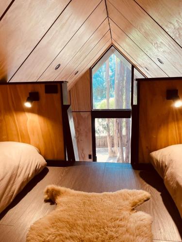 a room with two beds and a rug on the floor at Parque Laguna de Zapallar in Maitencillo