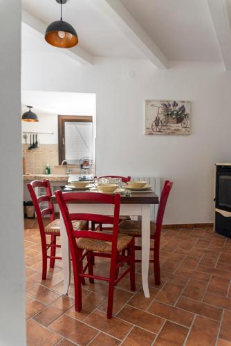 a dining room with a table and red chairs at Libera Mente in Fabriano