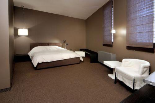 ベリ・イスカにあるThe Stone Villaのベッドルーム1室(ベッド1台、白い椅子2脚付)