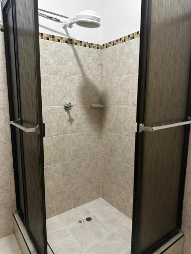 a shower with a glass door in a bathroom at Coliving habitacional in Cali