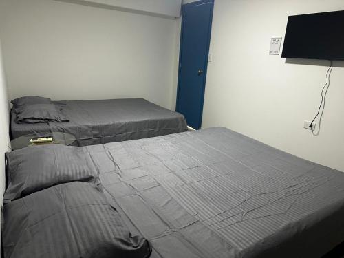 two twin beds in a room with a tv at Coliving habitacional in Cali