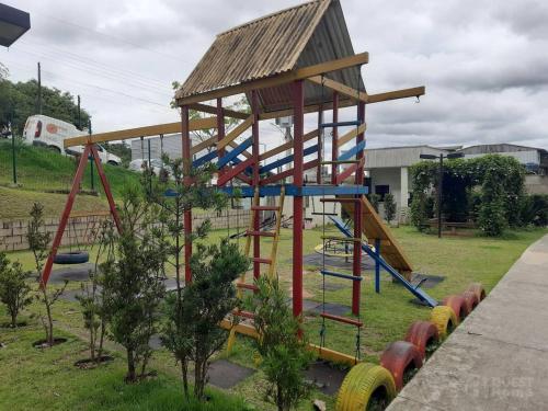a playground with a wooden play structure in a yard at Apartamento em Condomínio - 2 Dormitórios in Camboriú