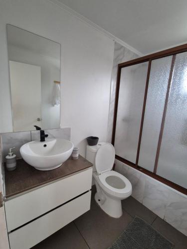 a white bathroom with a sink and a toilet at Cabaña Viaducto Vista al Mar, Curanipe in Pelluhue