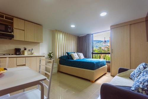 a small room with a bed and a kitchen with a view at Comuna Loft in Medellín