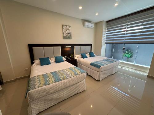a bedroom with two beds and a couch in it at HOTEL INNOVA in Tarija