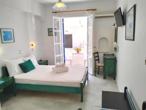a bedroom with a bed and a room with a table at Nostos Studios at Saint George beach Agios Georgios Chora Naxos town in Naxos Chora